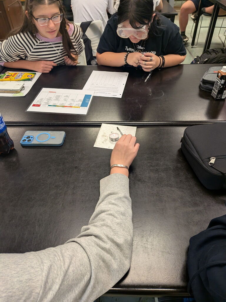students observe burnt piece of textile material