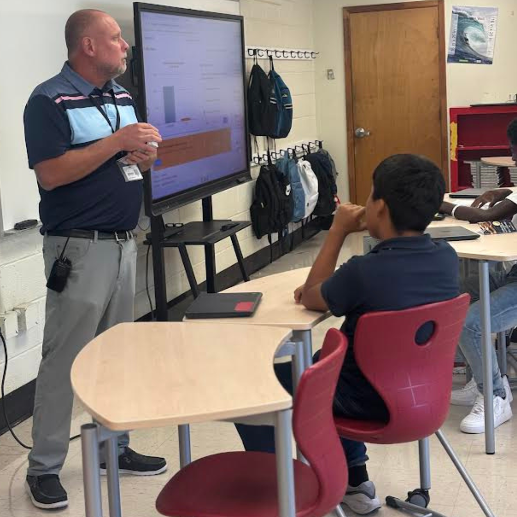 principal speaking to students in a classroom