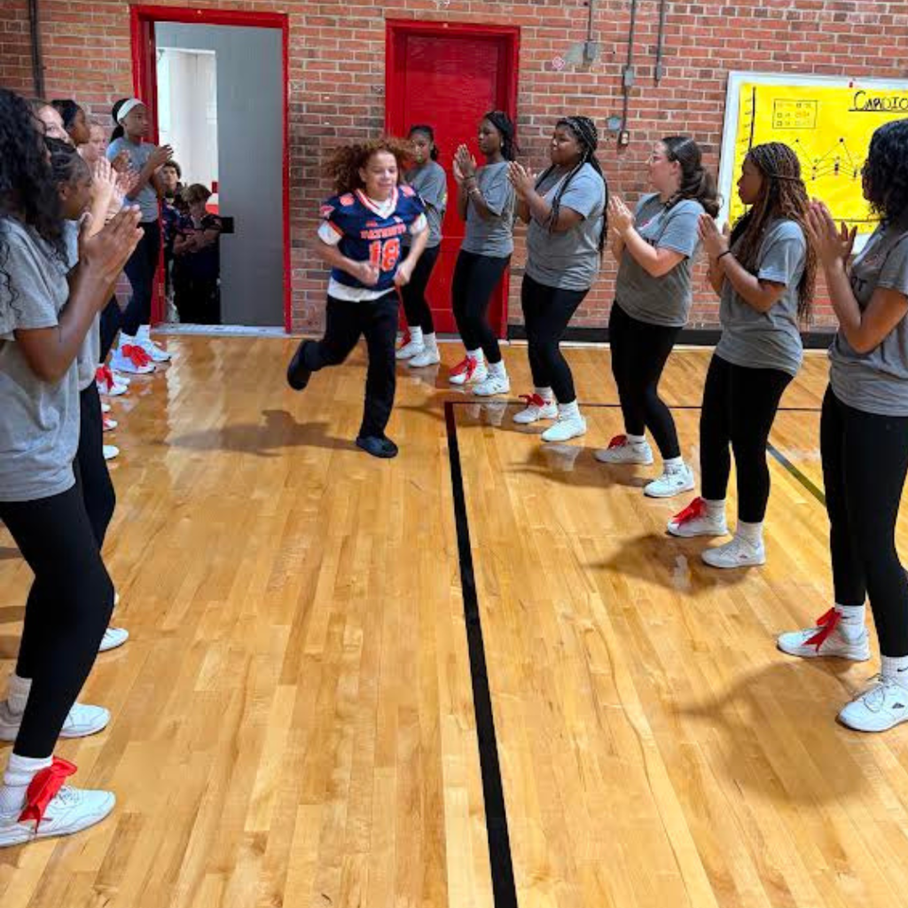 football player at pep rally with cheerleaders