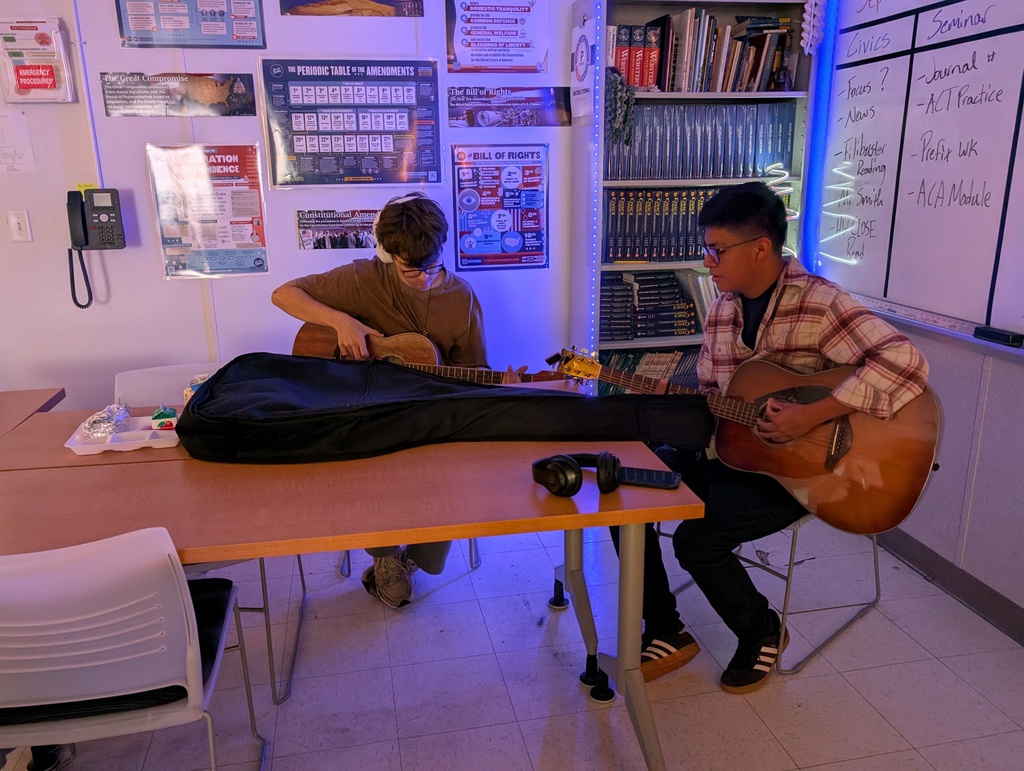 Students practicing guitar together during music club