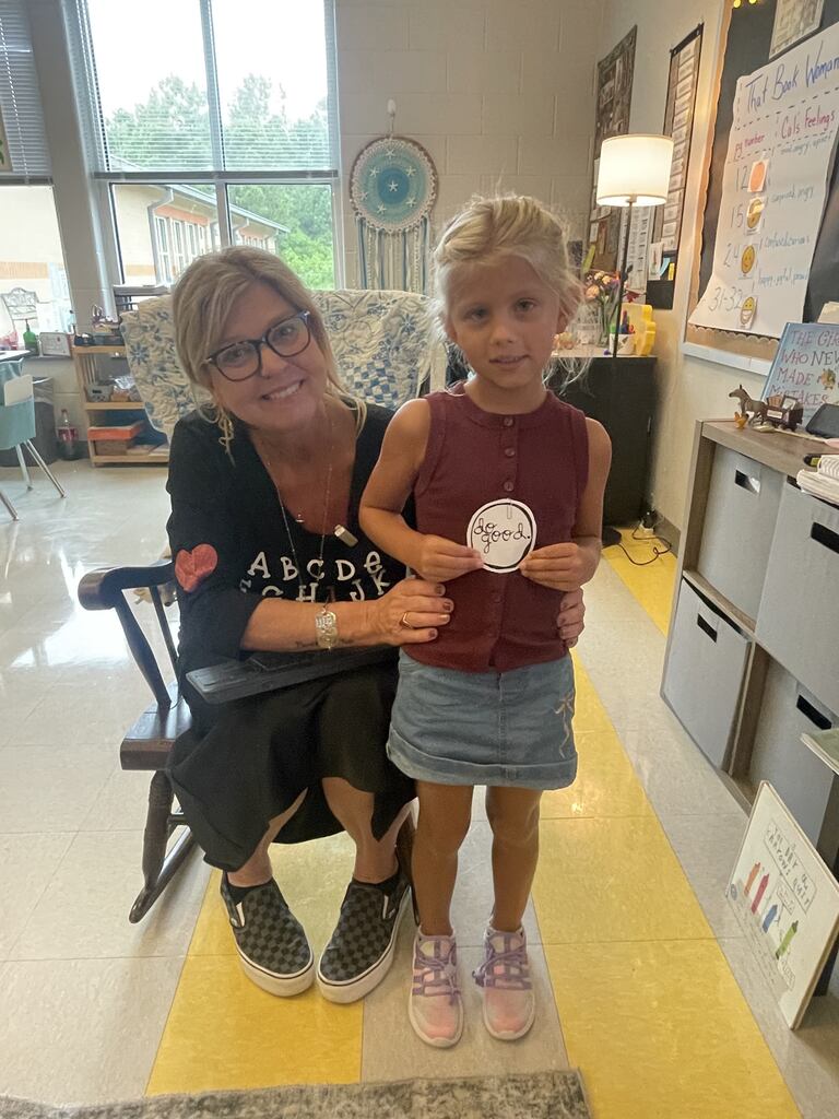 student holding a "do good" sticker