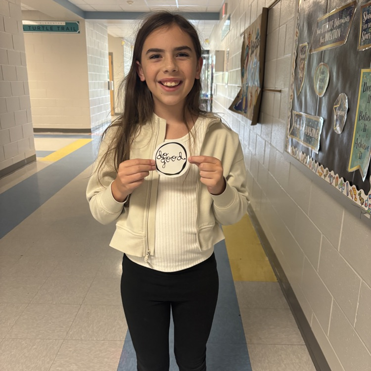student holding up a do good award 