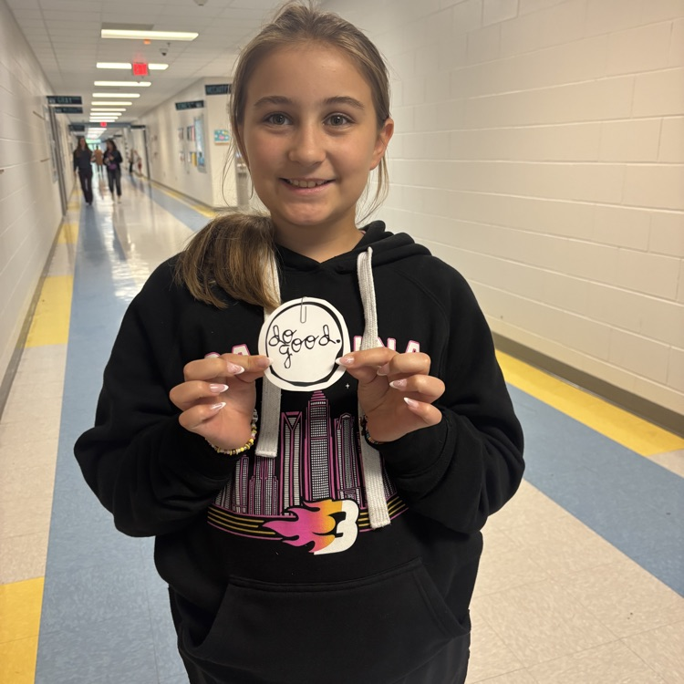student holding up a do good award 