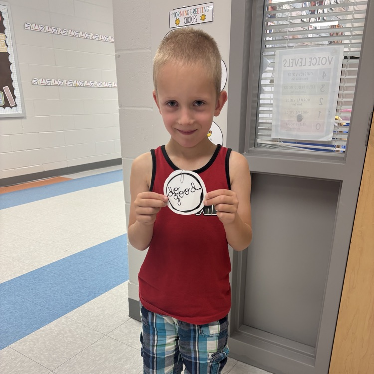 student holding up a do good award 