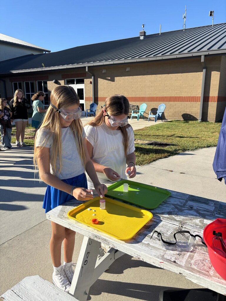 5th graders doing a science experiment outside