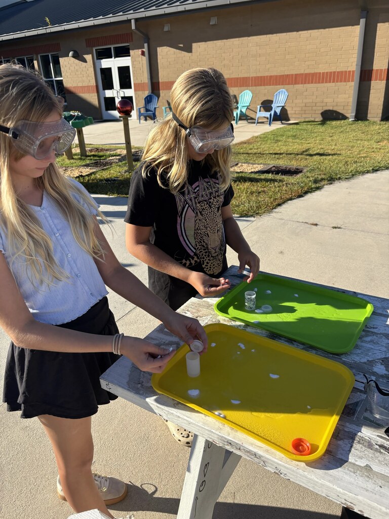 5th graders doing a science experiment outside