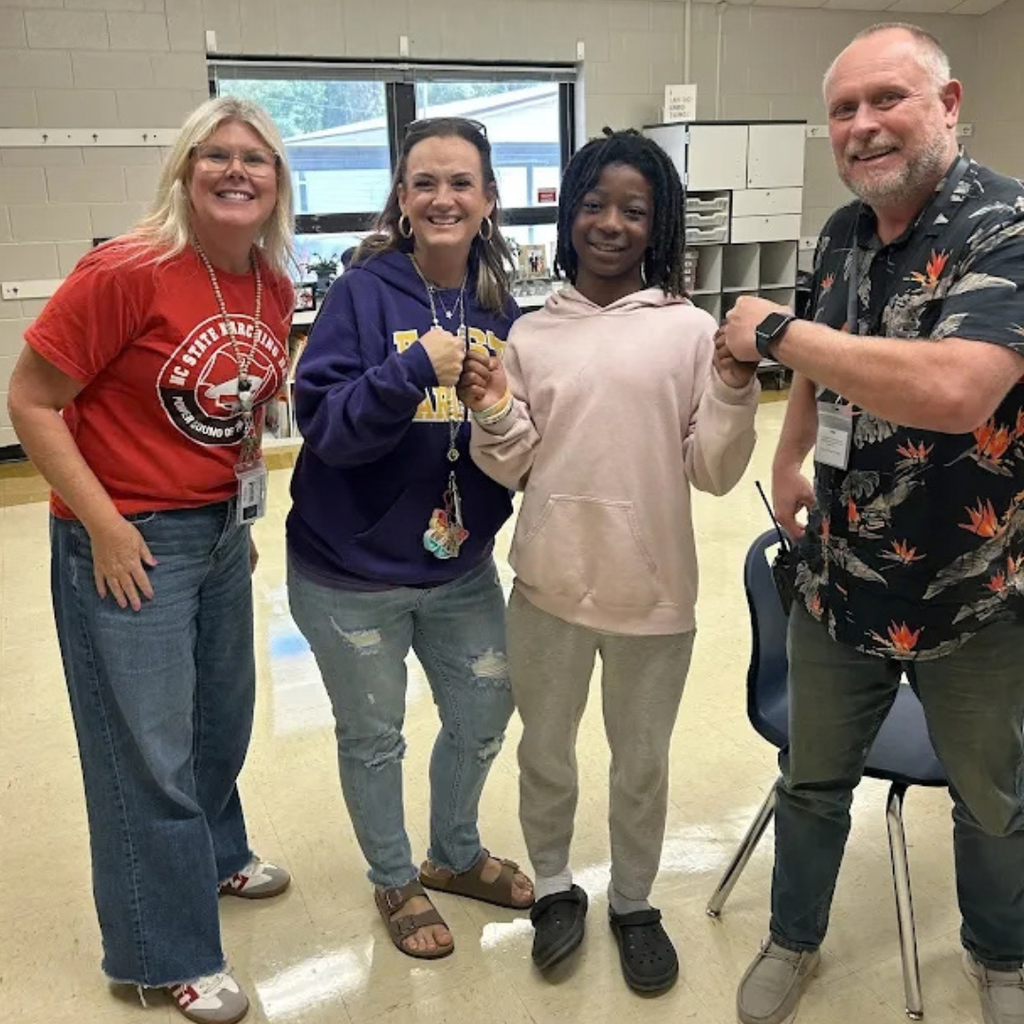 student posing with teachers