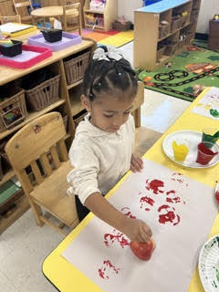 preK students painting with apples