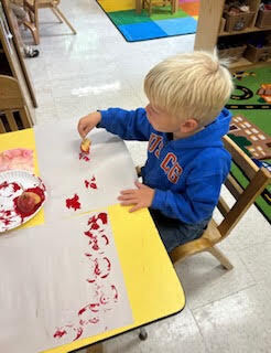 preK students painting with apples
