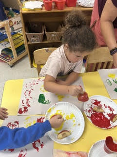 preK students painting with apples