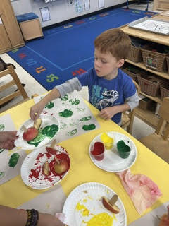 preK students painting with apples