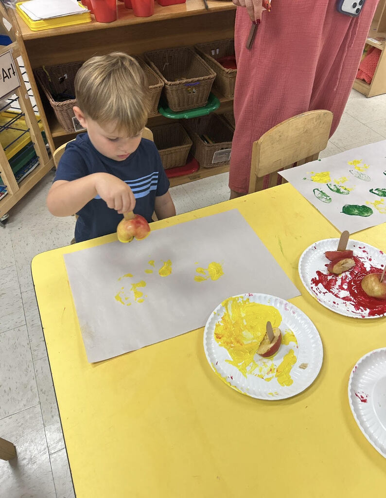 preK students painting with apples