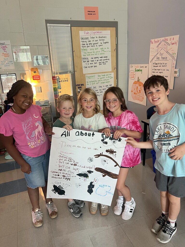 2nd graders working in small groups on a poster project