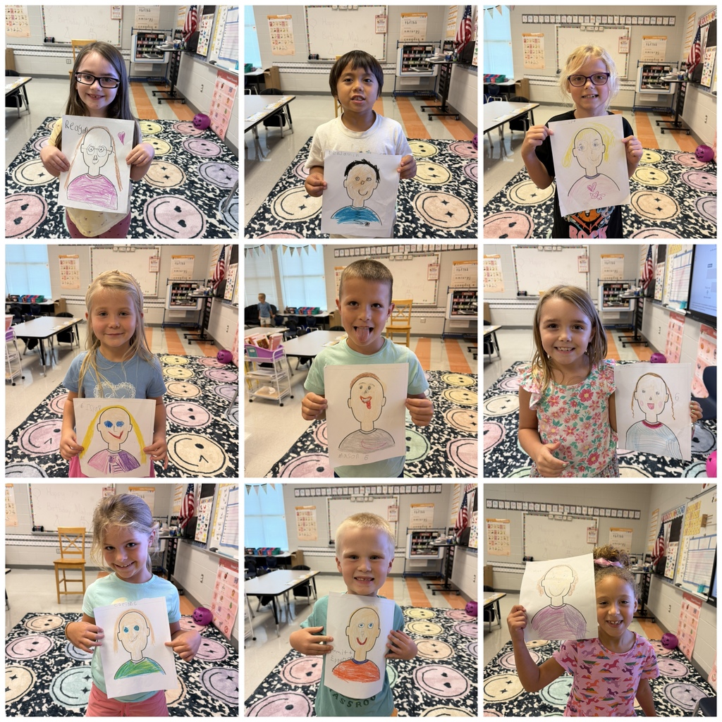 first graders holding their self portraits