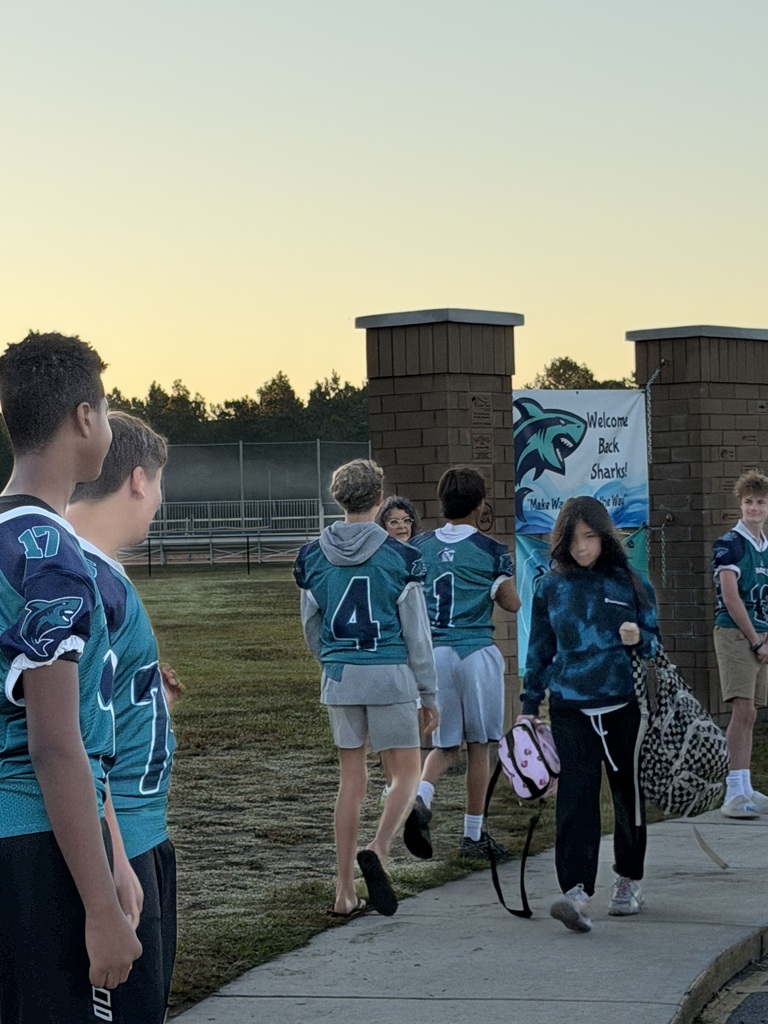 SCM Football students opening car doors for elementary students in the morning