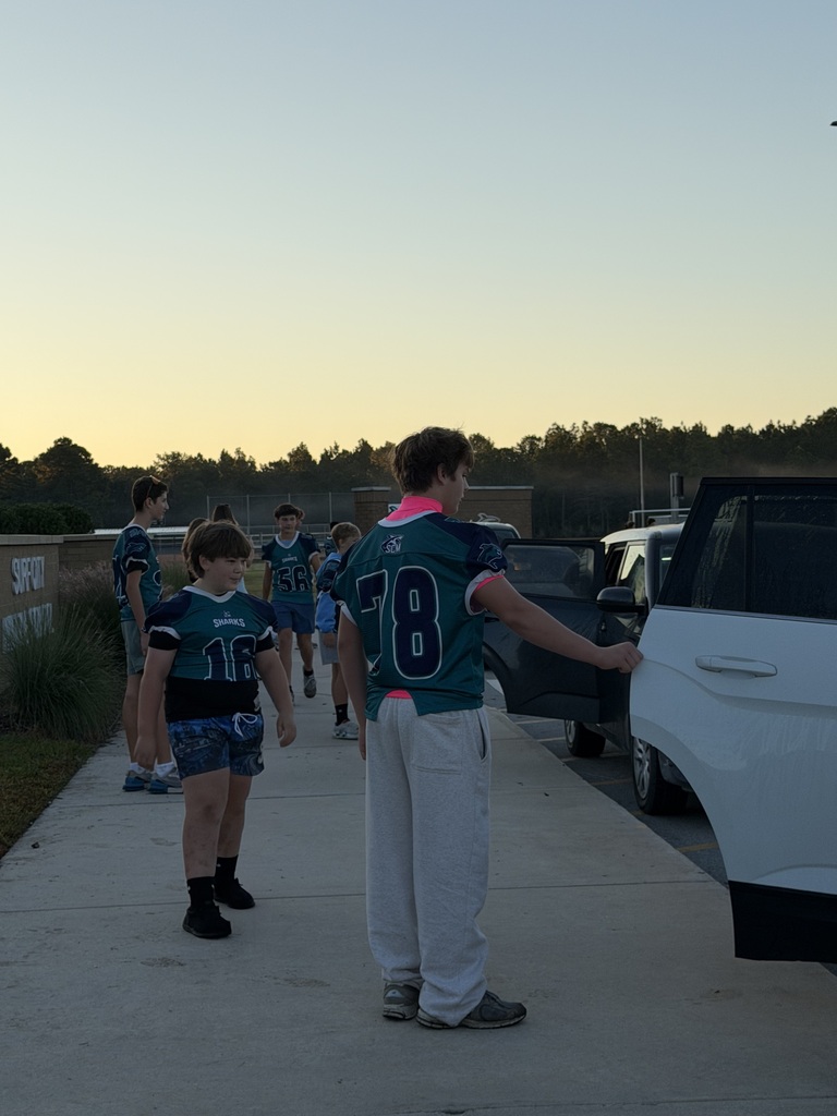 SCM Football students opening car doors for elementary students in the morning