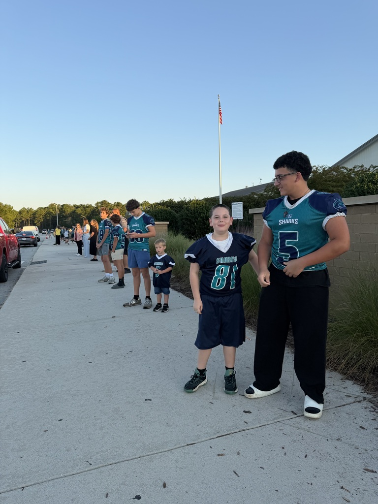 SCM Football students opening car doors for elementary students in the morning