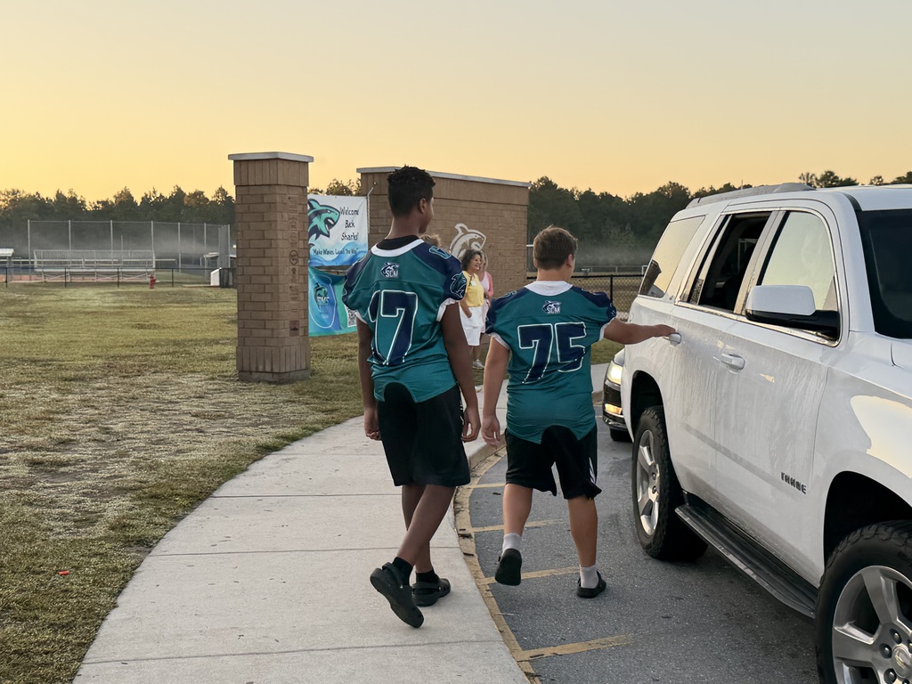 SCM Football students opening car doors for elementary students in the morning