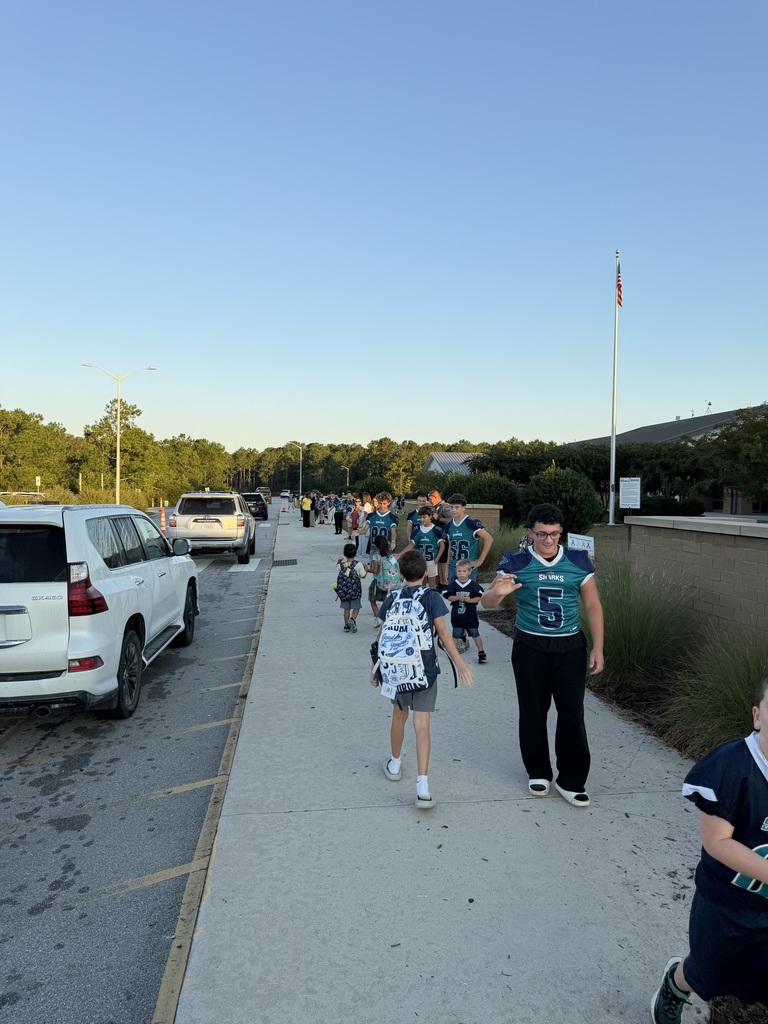 SCM Football students opening car doors for elementary students in the morning