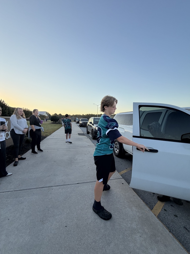 SCM Football students opening car doors for elementary students in the morning