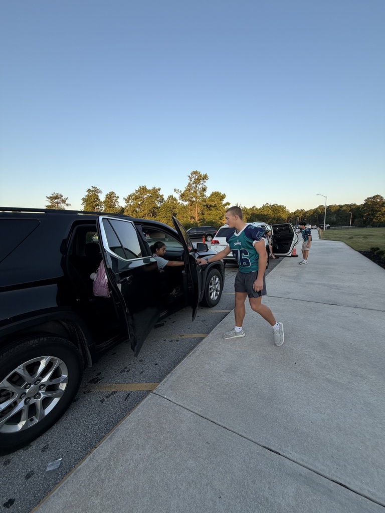 SCM Football students opening car doors for elementary students in the morning