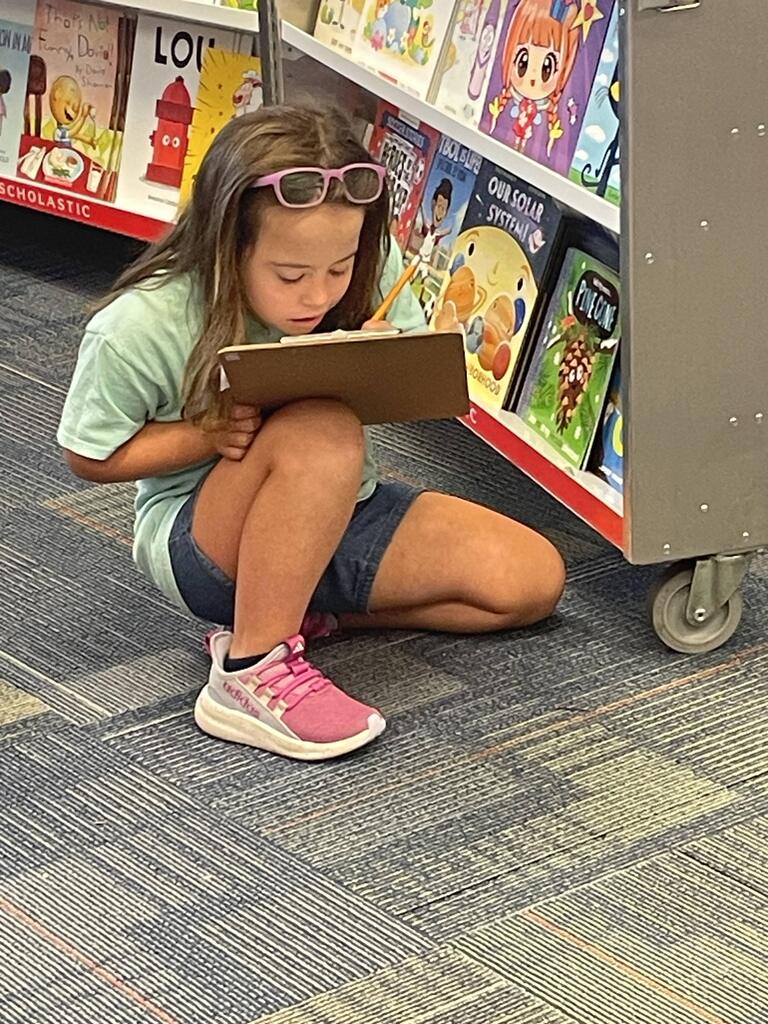 students sitting on the couch reading book fair books