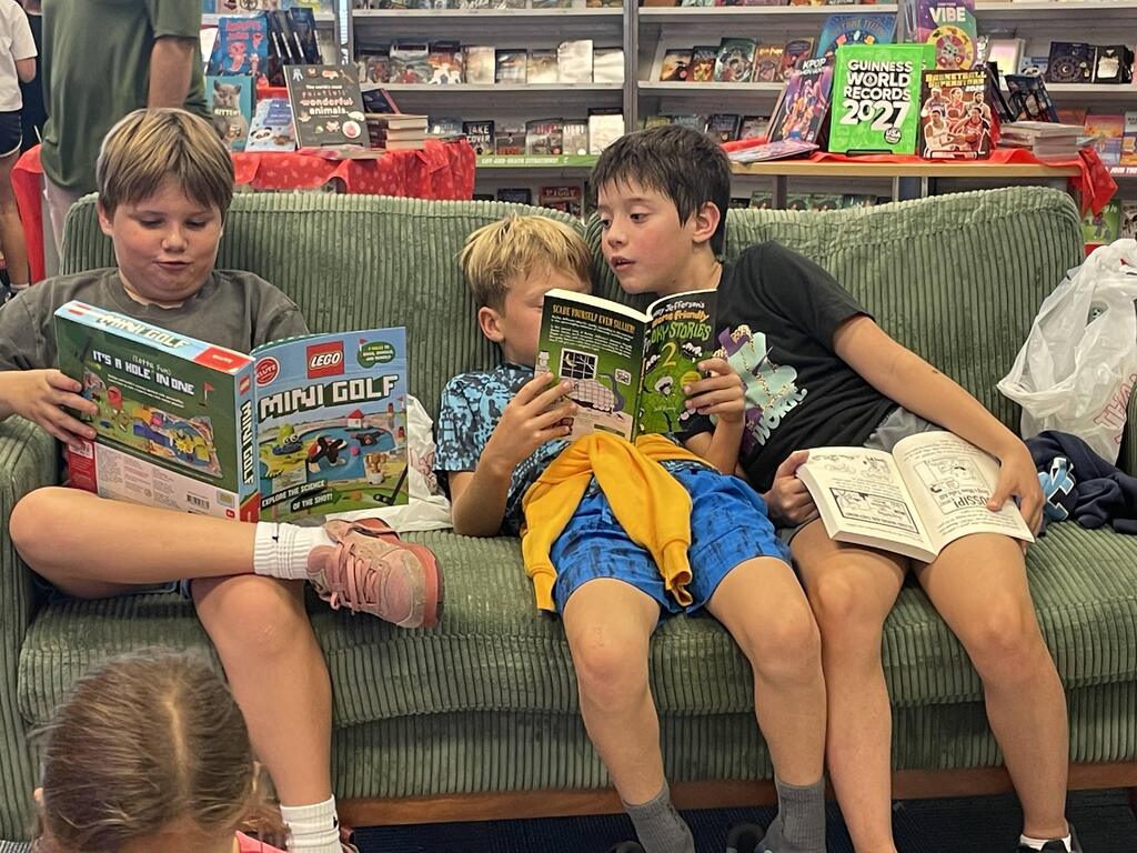 students sitting on the couch reading book fair books