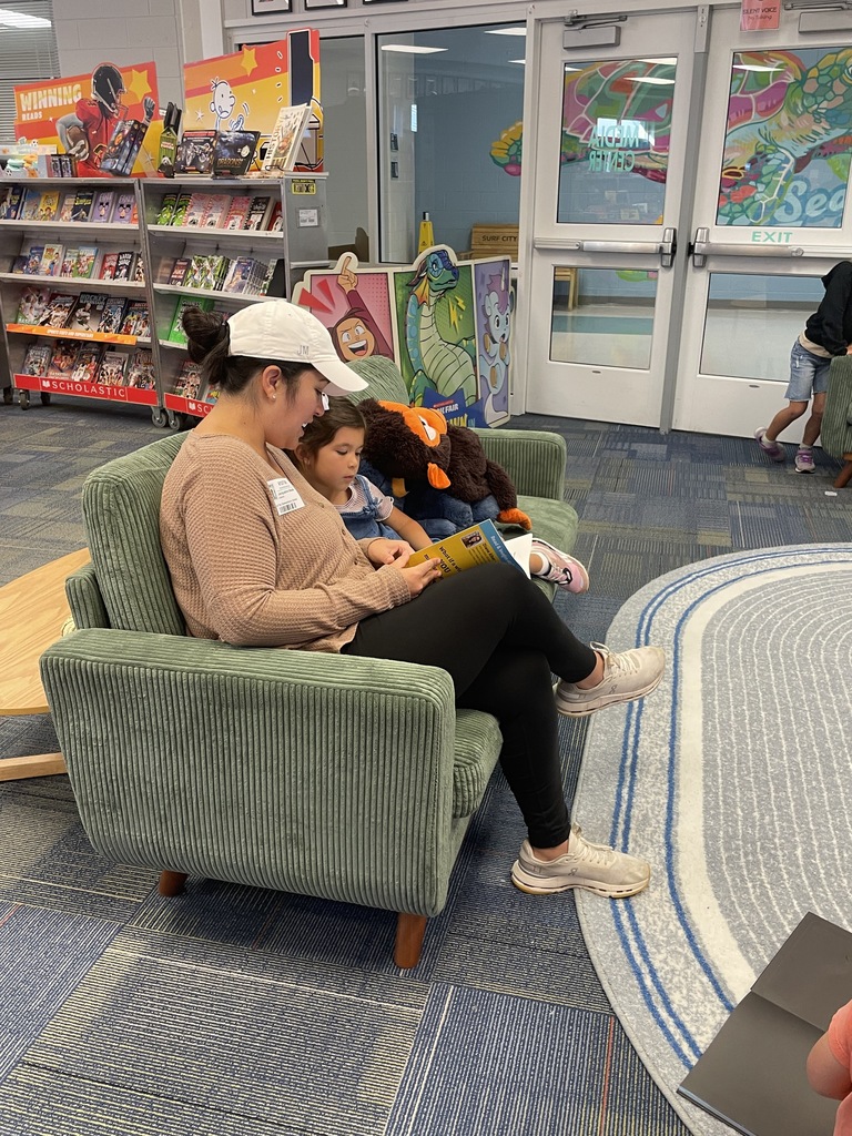 students sitting on the couch reading book fair books