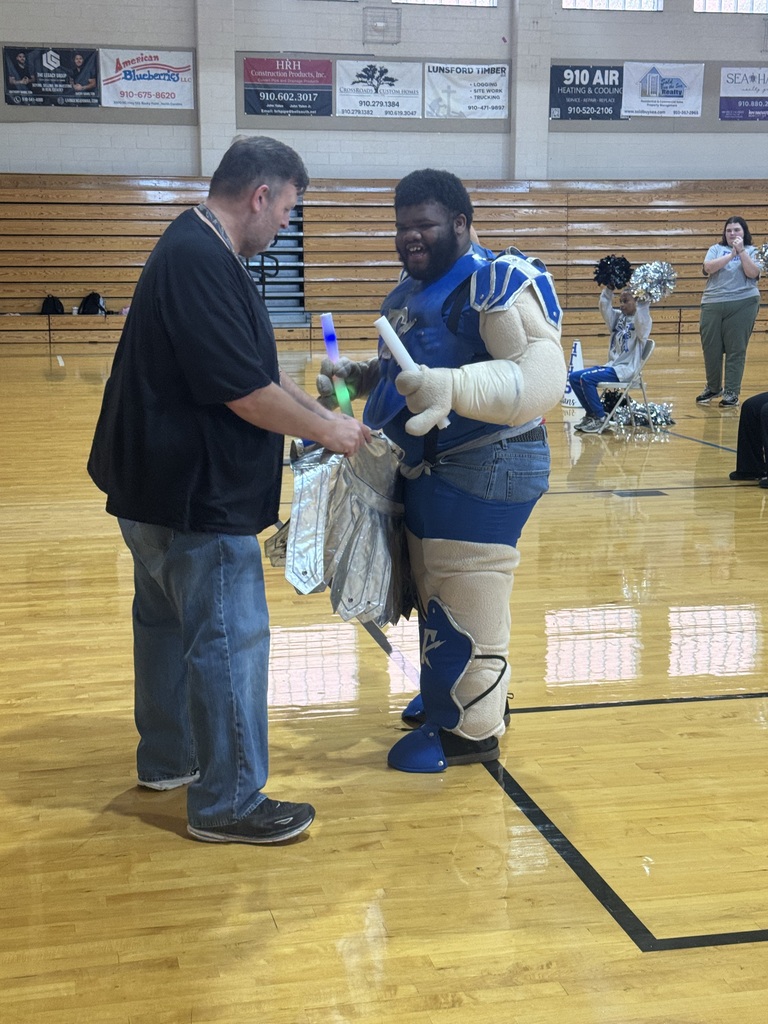student in mascot speaks with teacher