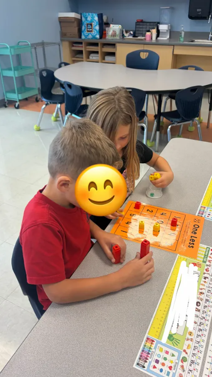 Kindergarten students playing a math game at their tables