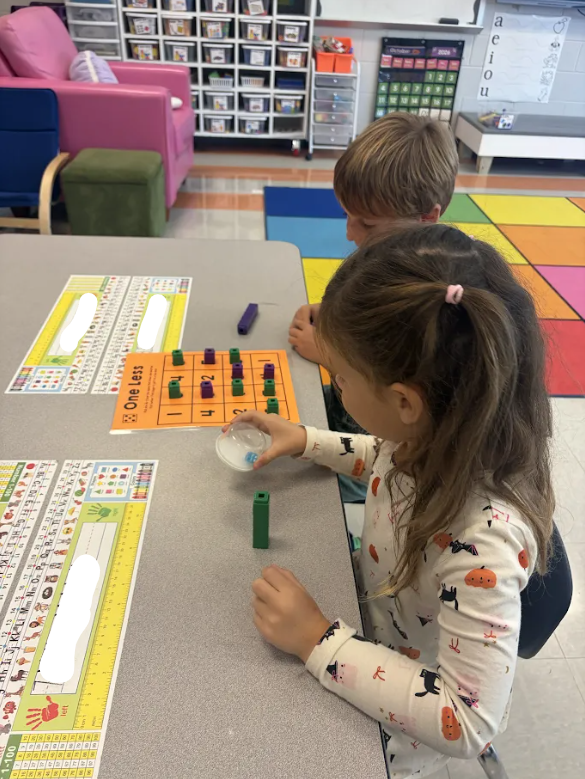 Kindergarten students playing a math game at their tables