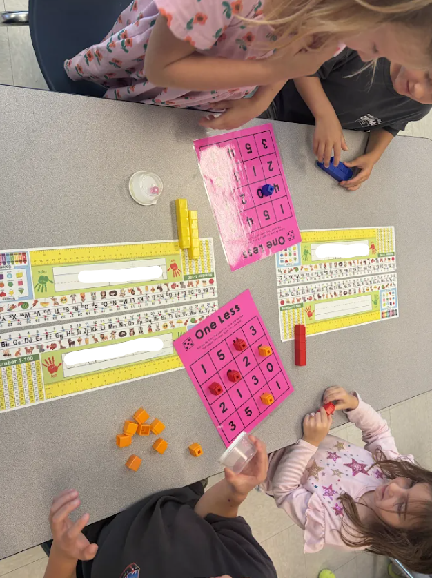 Kindergarten students playing a math game at their tables