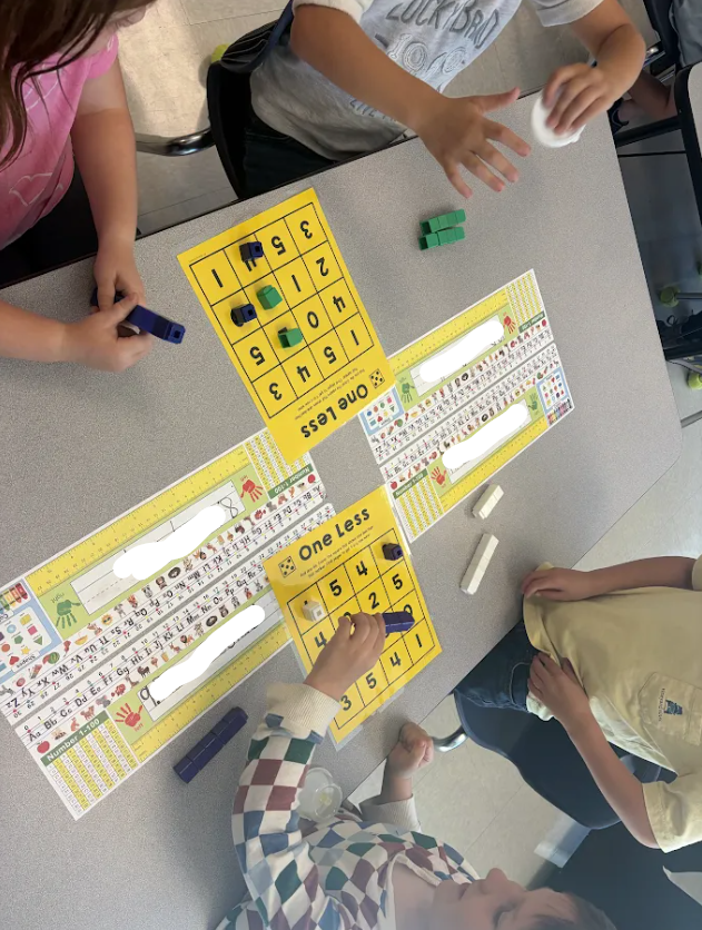 Kindergarten students playing a math game at their tables