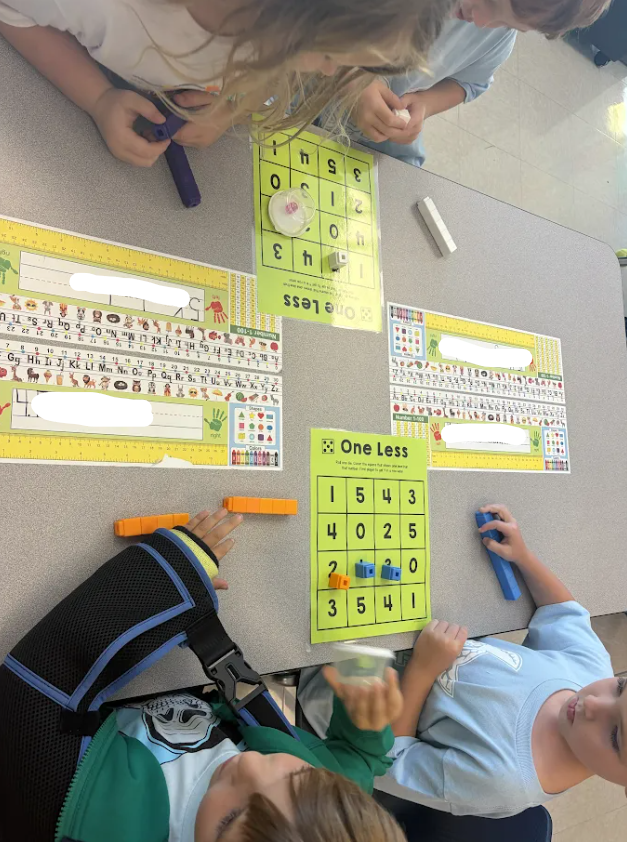 Kindergarten students playing a math game at their tables