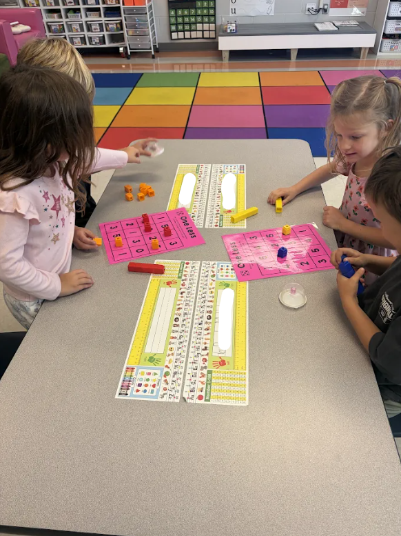 Kindergarten students playing a math game at their tables