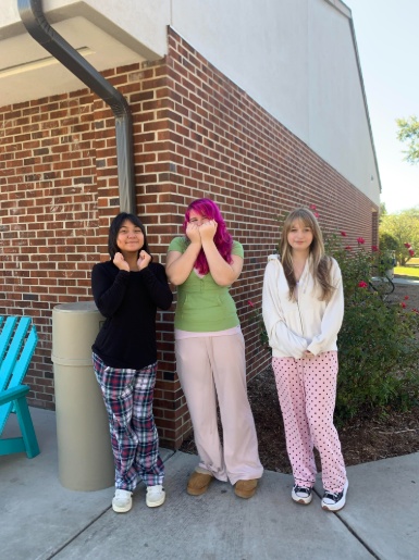 Three students posing for a picture in their pajamas.