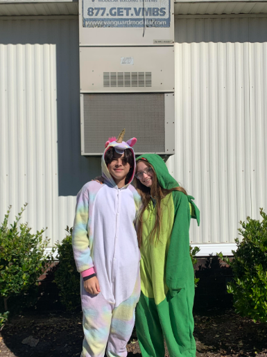 Two students posing for a picture in their pajamas.