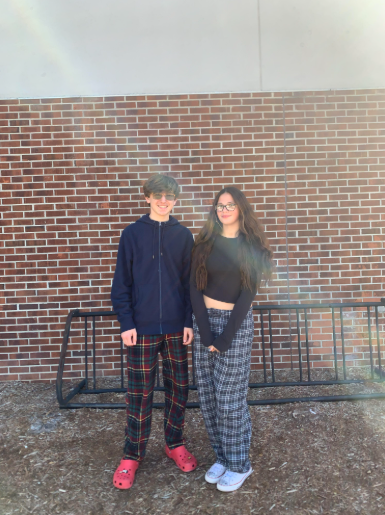 Two students posing for a picture in their pajamas.
