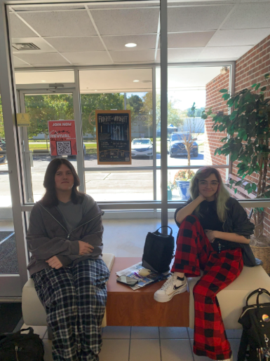 Two students posing for a picture in their pajamas.