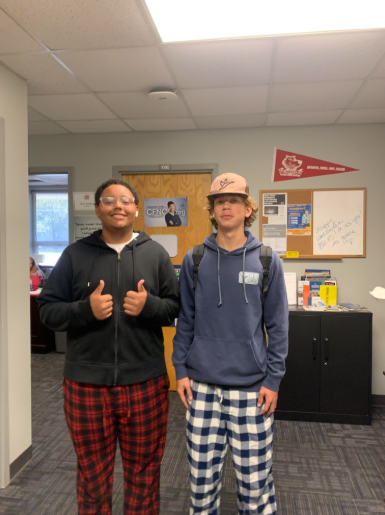 Two students posing for a picture in their pajamas.