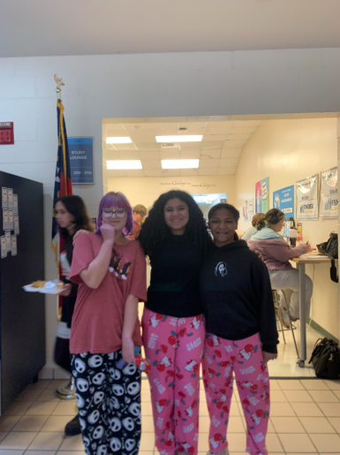 Three students posing for a picture in their pajamas.