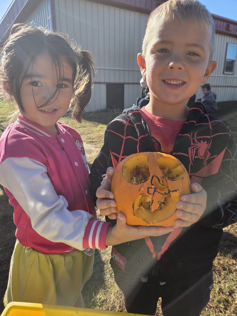 PreK students working on gutting a pumpkin