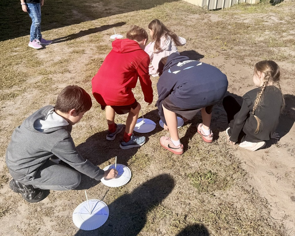 3rd graders outside using a homemade sun dial