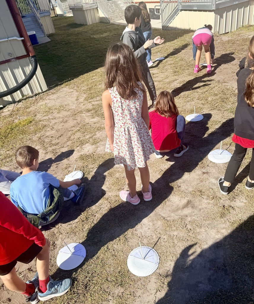3rd graders outside using a homemade sun dial
