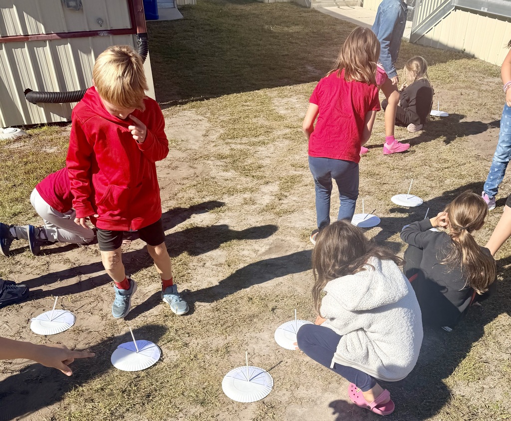 3rd graders outside using a homemade sun dial
