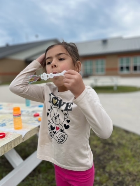 kindergarten kid blowing bubbles