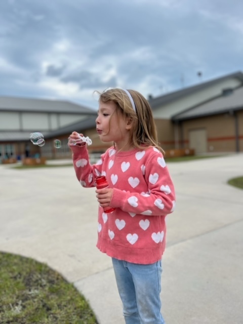kindergarten kid blowing bubbles