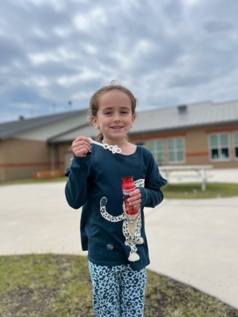 kindergarten kid blowing bubbles