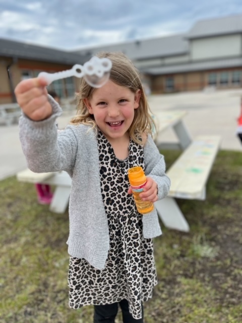 kindergarten kid blowing bubbles