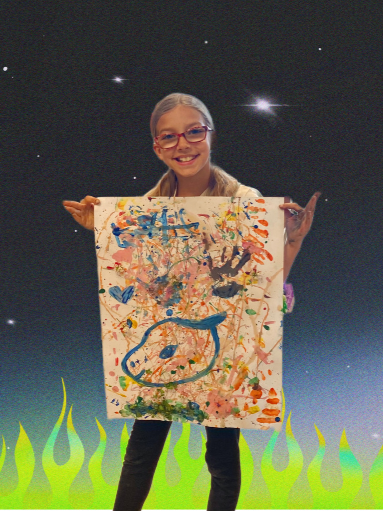 3rd grade student holding up their painting art work